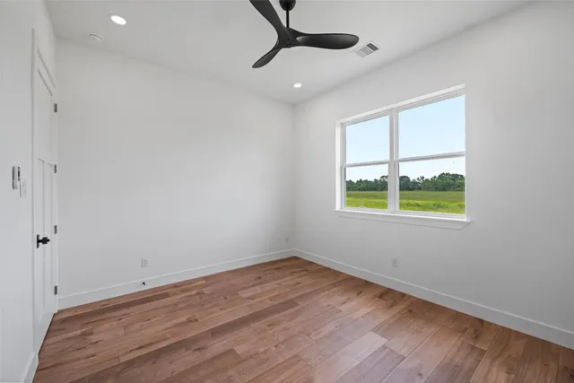 a view of empty room with wooden floor