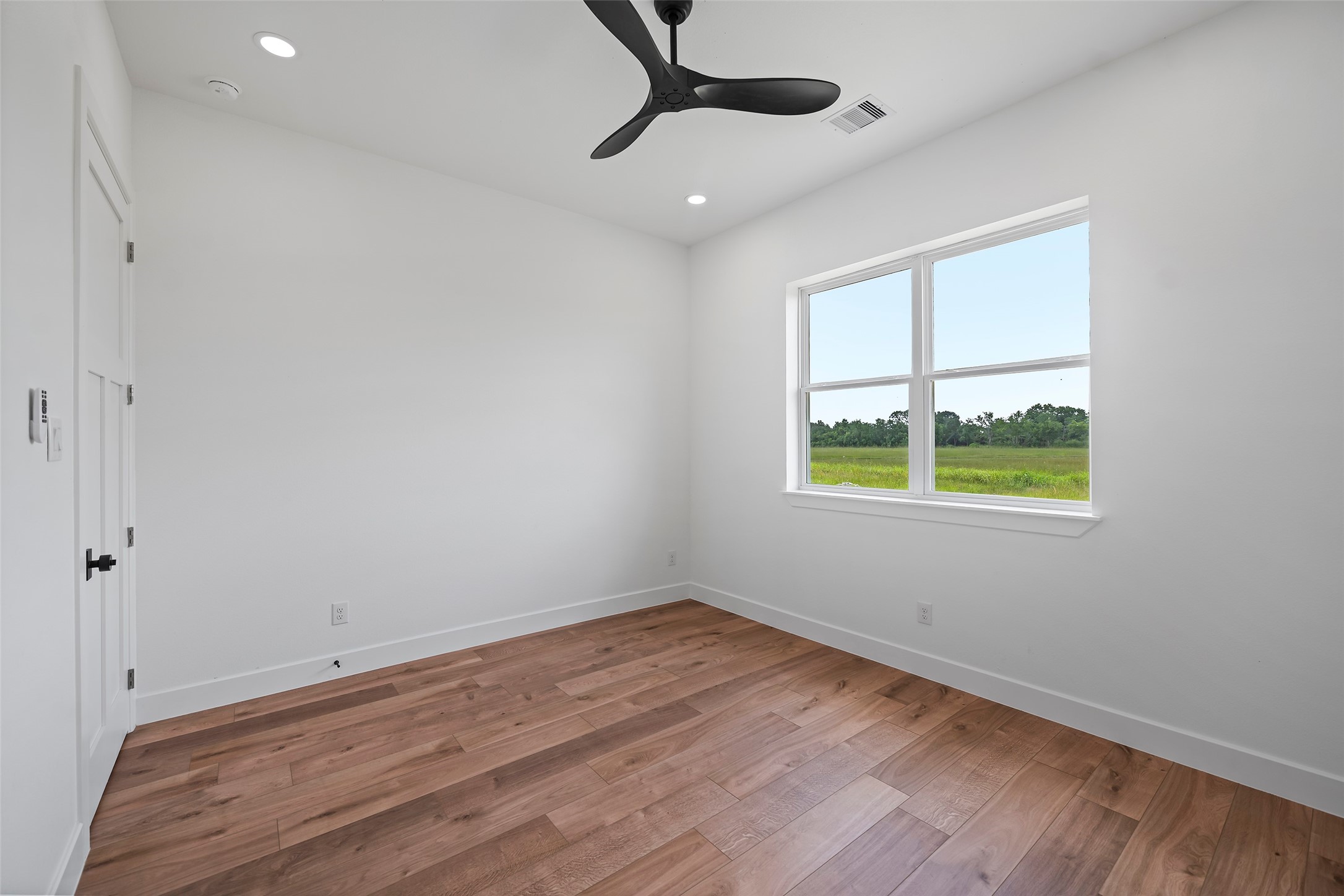 413 Chuckwagon Trail Angleton, TX 77515 - Photo 44 of 46 a view of an empty room with a window and wooden floor