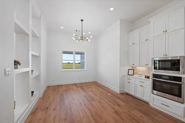 a view of kitchen with microwave and cabinets