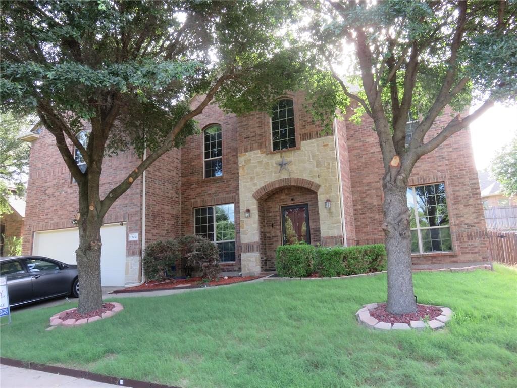 1122 Walter Stephenson Road Midlothian, TX 76065 - Photo 3 of 26 Brick and stone facade featuring an arched entryway, two prominent trees, a two-car garage, and established landscaping
