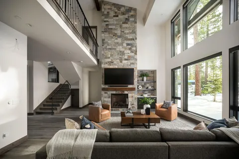 a living room with furniture fireplace and large windows