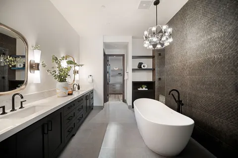 a white bath tub sitting in a bathroom next to a window