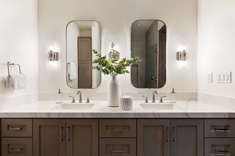 a bathroom with double vanity sinks and a mirror