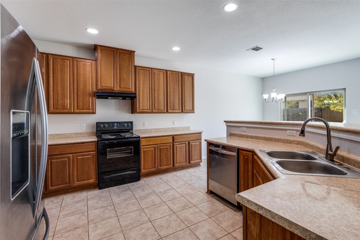 211 Mancos Drive Georgetown, TX 78626 - Photo 5 of 25 a kitchen with granite countertop a sink and stainless steel appliances
