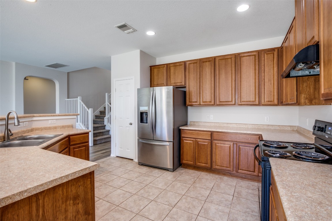 211 Mancos Drive Georgetown, TX 78626 - Photo 6 of 25 a kitchen with stainless steel appliances granite countertop a sink stove and refrigerator