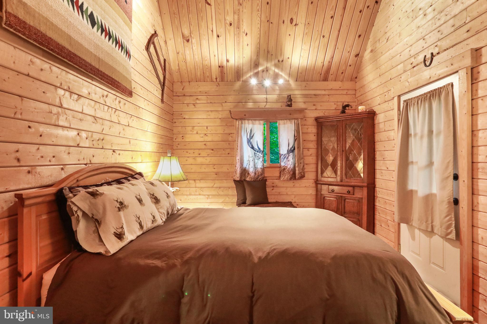 333 Rouse Mountain Road Great Cacapon, WV 25422 - Photo 17 of 54 a bedroom with a bed and chandelier