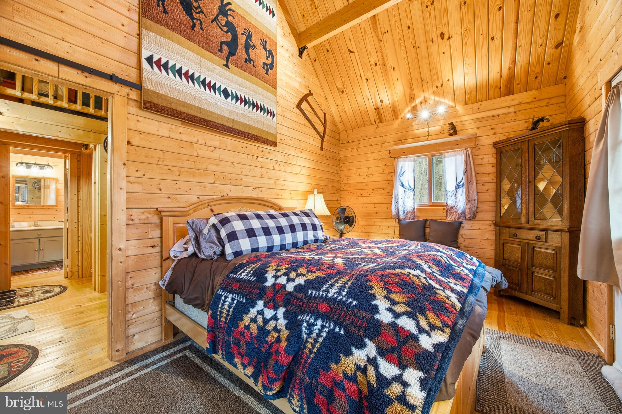 333 Rouse Mountain Road Great Cacapon, WV 25422 - Photo 18 of 54 a bedroom with a bed and wooden floor