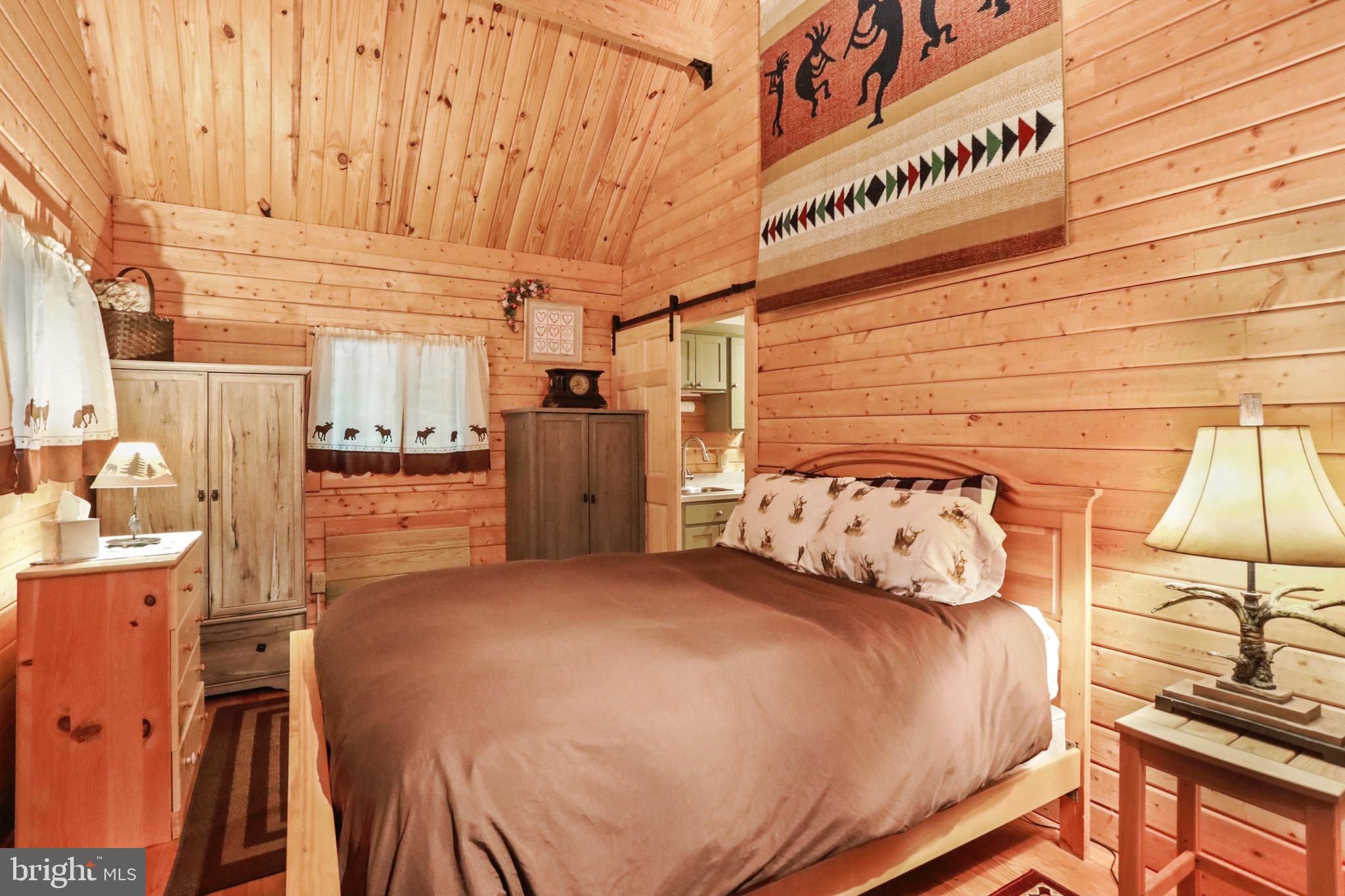 333 Rouse Mountain Road Great Cacapon, WV 25422 - Photo 19 of 54 a bedroom with a bed next to a window