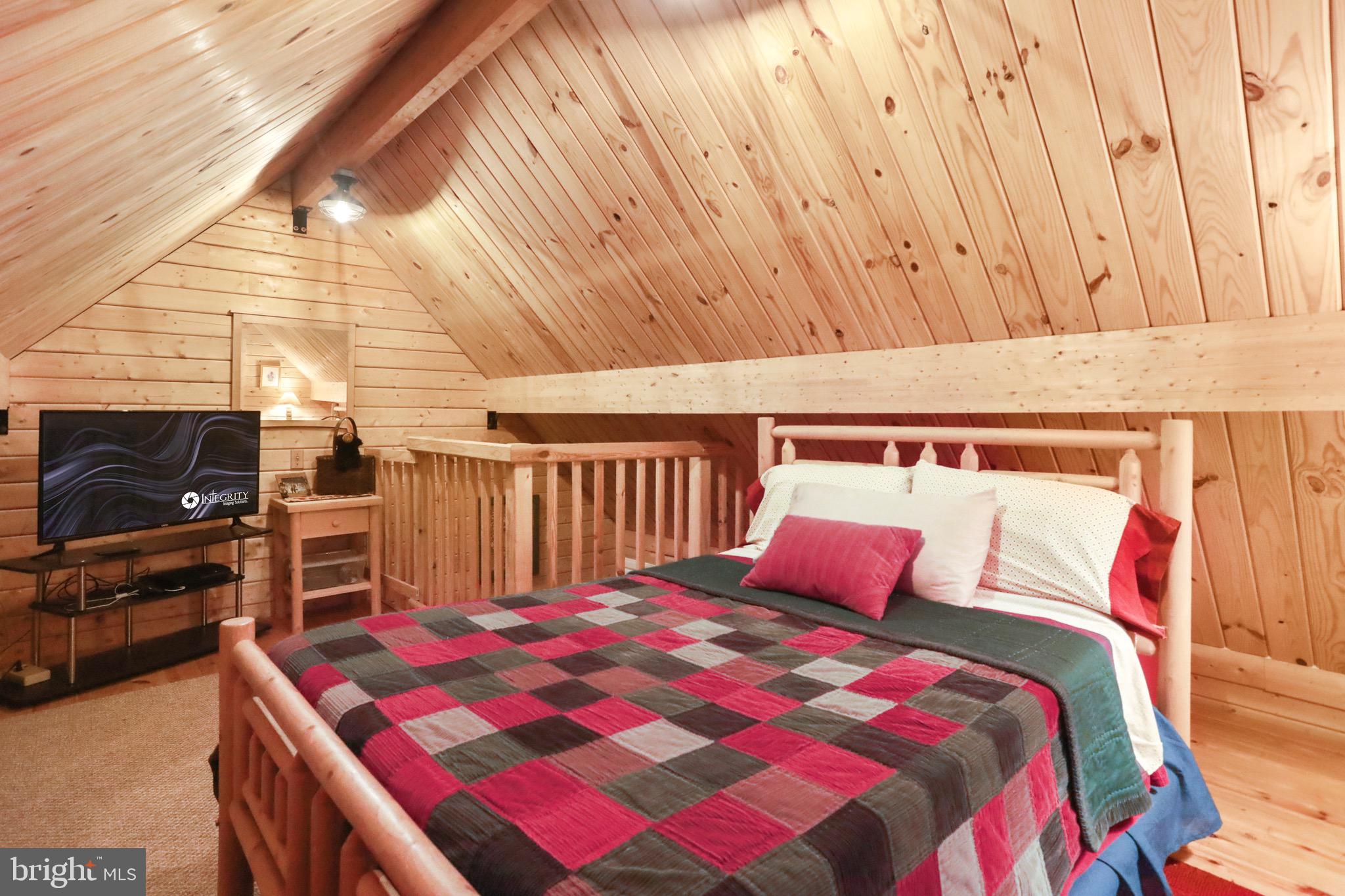 333 Rouse Mountain Road Great Cacapon, WV 25422 - Photo 26 of 54 a bed sitting in a bedroom next to a window with balcony
