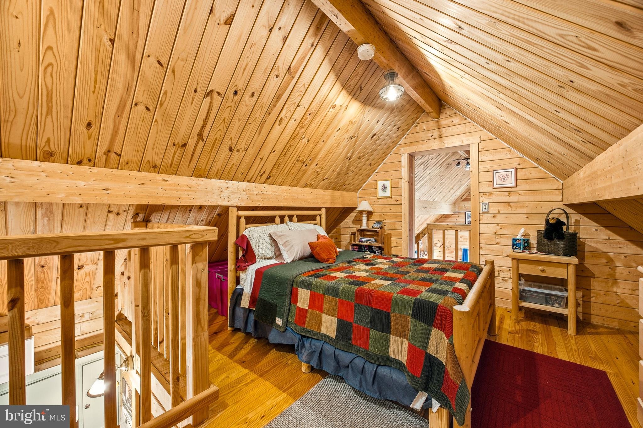 333 Rouse Mountain Road Great Cacapon, WV 25422 - Photo 27 of 54 a bedroom with two beds and wooden floor