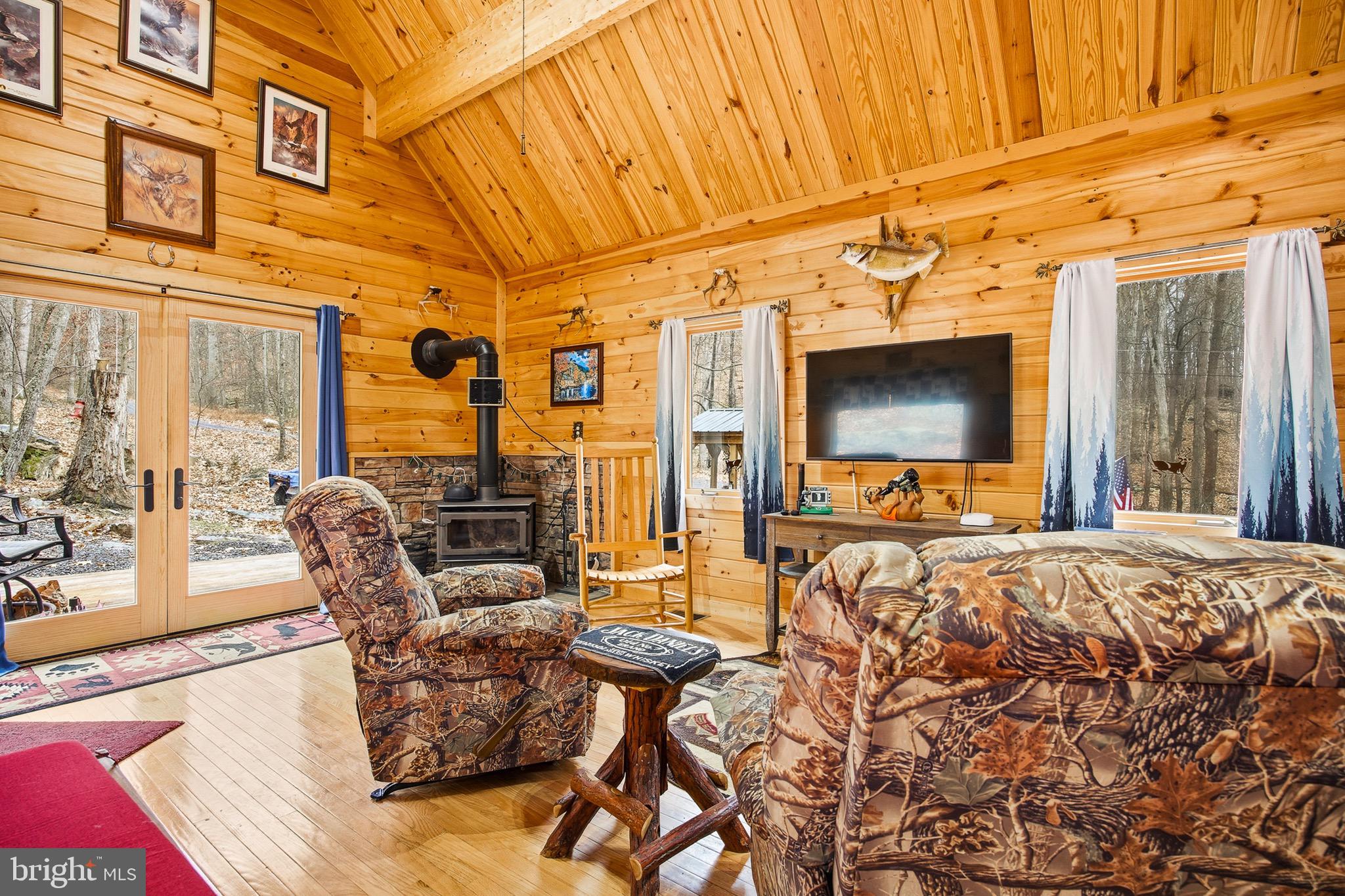 333 Rouse Mountain Road Great Cacapon, WV 25422 - Photo 6 of 54 a living room with patio furniture and a flat screen tv
