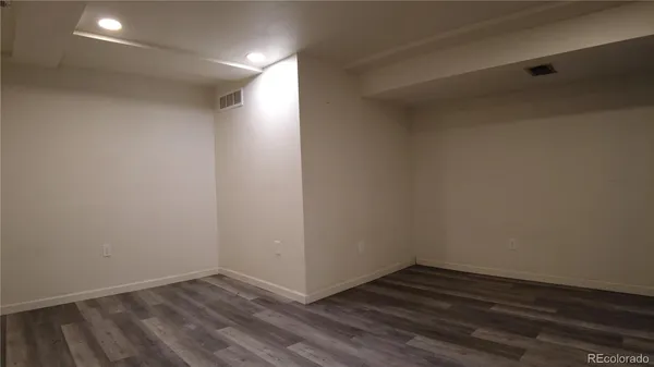 a view of an empty room with wooden floor