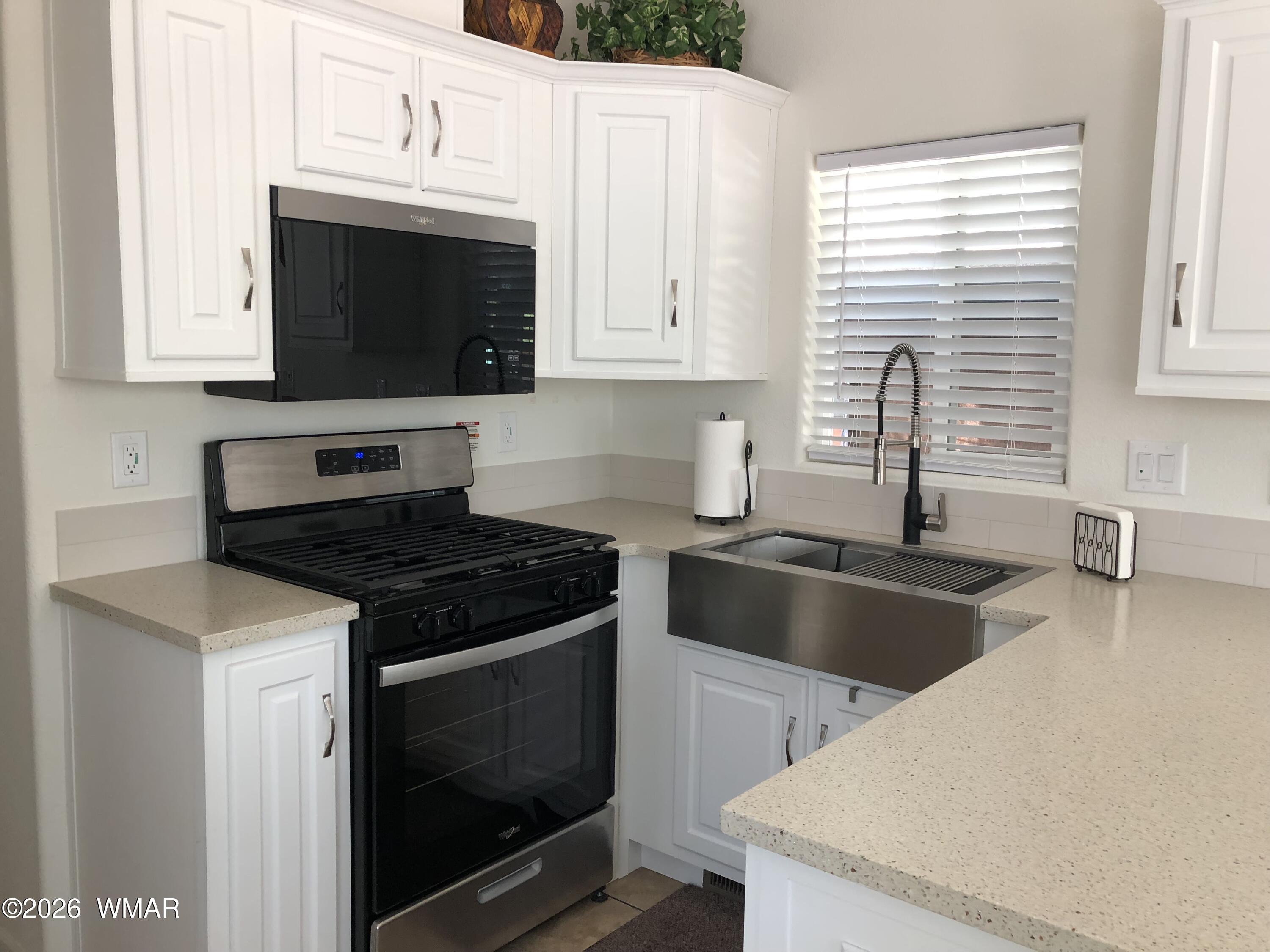 2301 Turtle Creek Road Show Low, AZ 85901 - Photo 15 of 35 a kitchen with granite countertop a sink dishwasher a stove and a microwave oven with cabinets