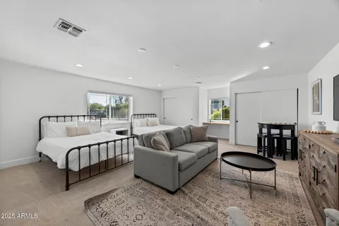 a spacious bedroom with a bed a couch a table and chair