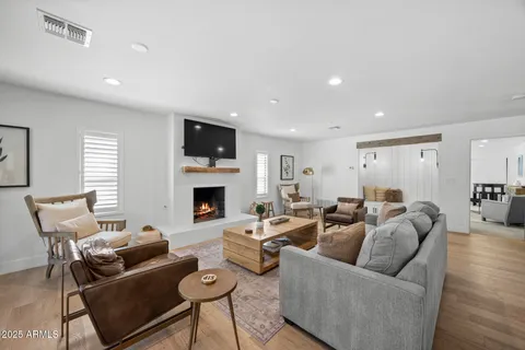 a living room with furniture a flat screen tv and a fireplace