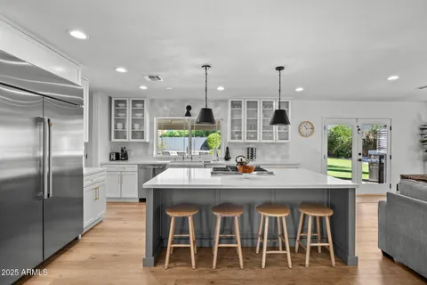 a kitchen with kitchen island granite countertop a sink and refrigerator