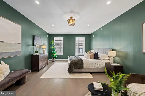 a view of hallway with an empty room and wooden floor