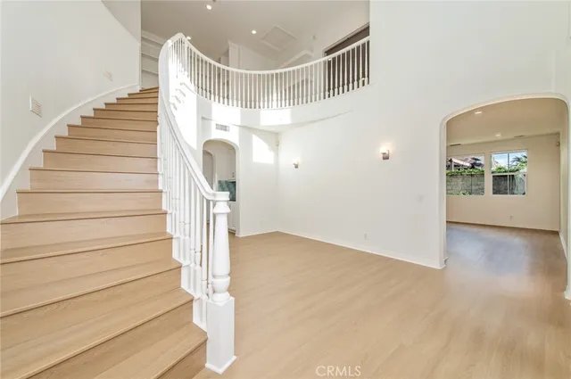 a large white kitchen with cabinets and a stainless steel refrigerator