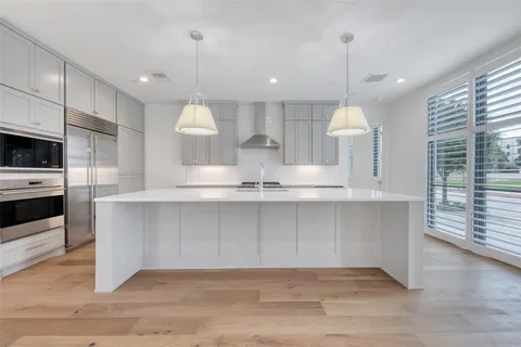 a large kitchen with a large window a oven and stainless steel appliances