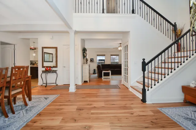 a view of a hallway with dining room and wooden floor