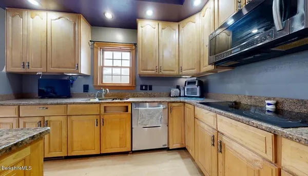 a kitchen with stainless steel appliances granite countertop dining table chairs and granite counter tops