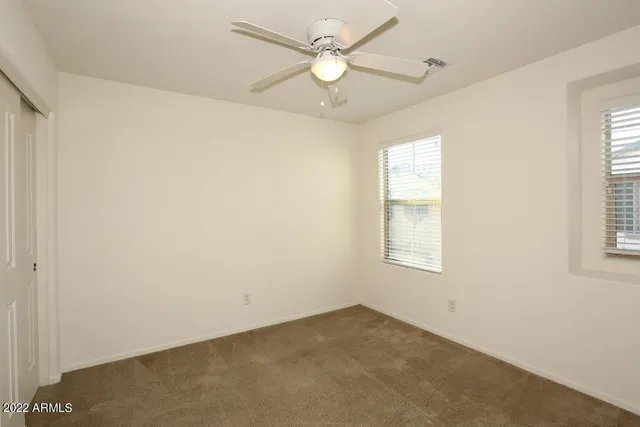 an empty room with a window and a fan