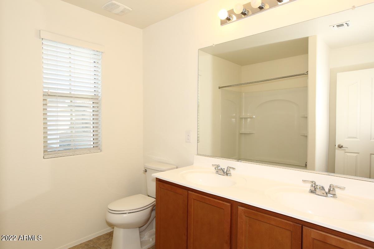 4717 East Betty Elyse Lane Phoenix, AZ 85032 - Photo 15 of 25 a bathroom with a sink a toilet and a mirror