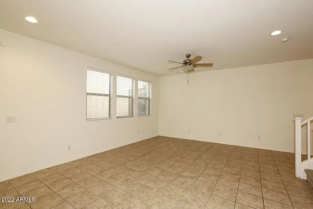 an empty room with a ceiling fan and a window