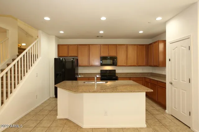a kitchen with stainless steel appliances granite countertop a sink a stove a refrigerator and a refrigerator