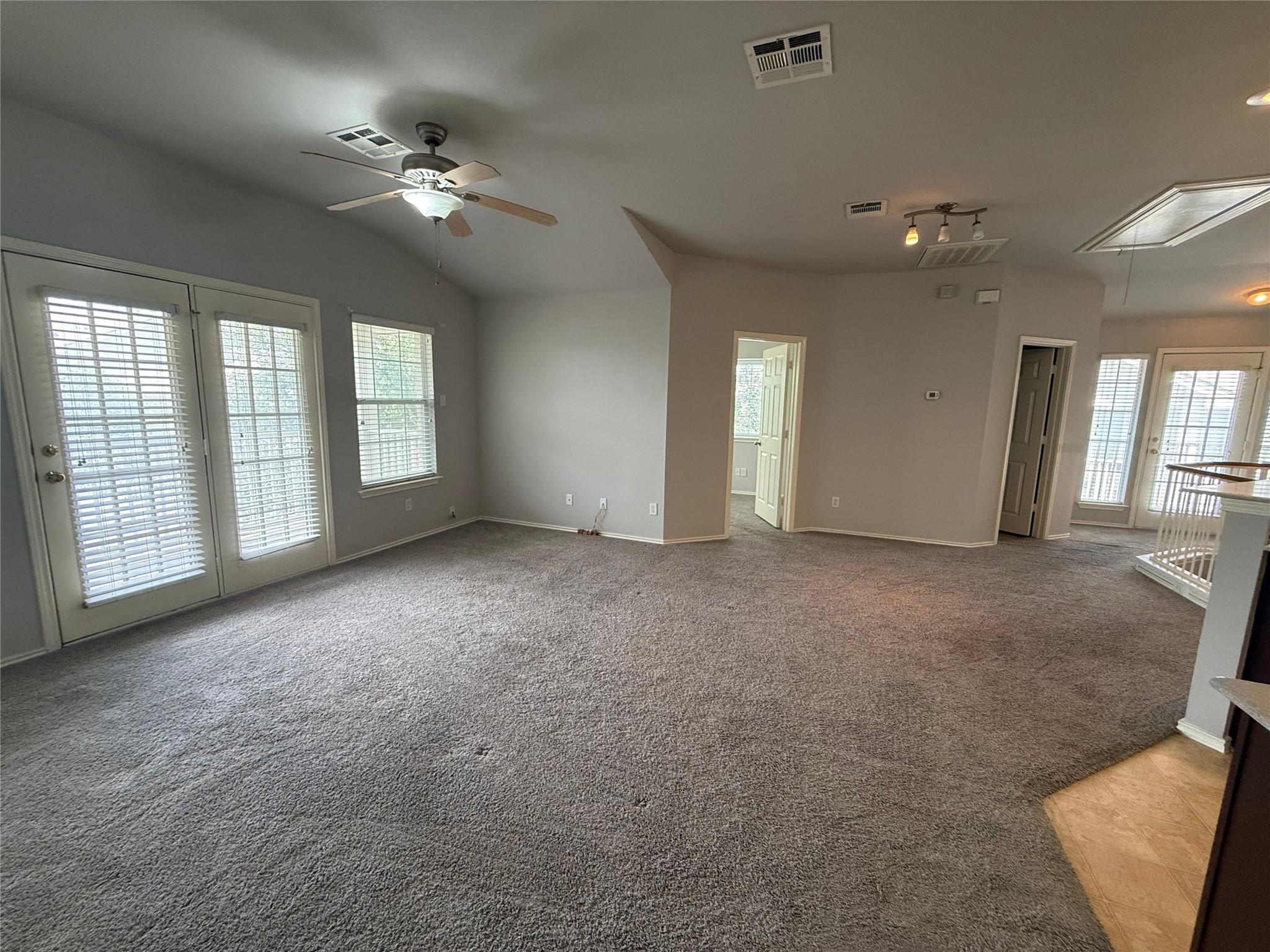 1900 Scofield Ridge Parkway, Unit 4701 Austin, TX 78727 - Photo 9 of 27 A spacious living area with vaulted ceilings and ample natural light from glass doors and large windows.