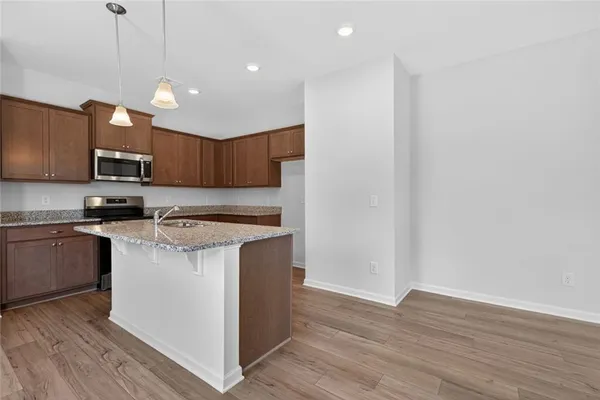 a kitchen with a sink a microwave a stove and cabinets