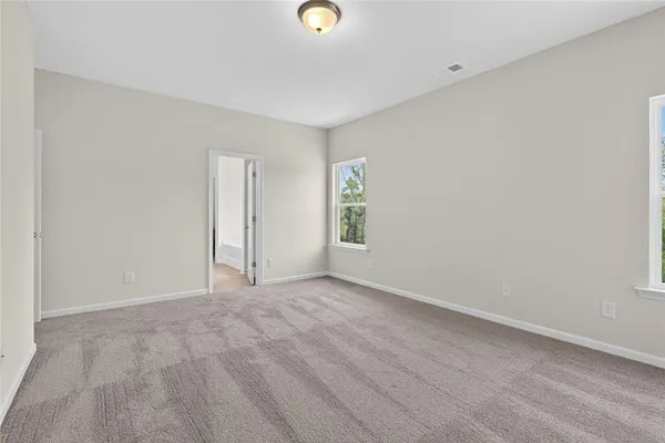 a view of an empty room with window and closet area