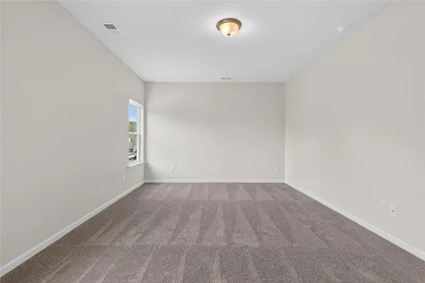 an empty room with wooden floor and white walls