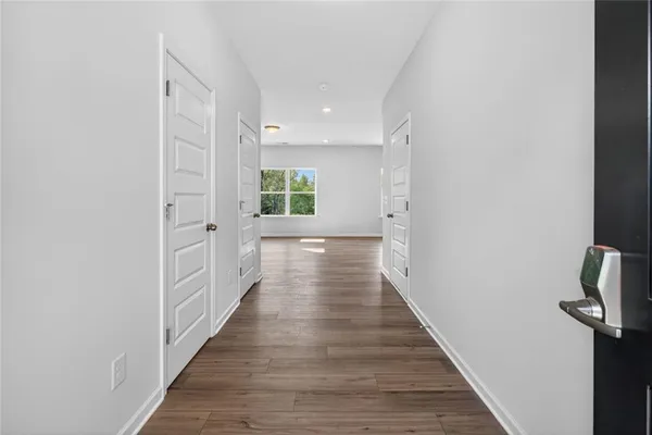 a view of a hallway with wooden floor and staircase