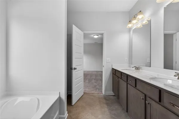 a bathroom with a tub sink and mirror