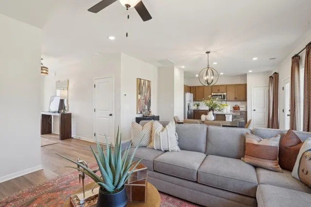 a living room with furniture a chandelier and a dining room