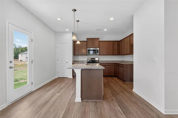 a kitchen with a refrigerator a sink and wooden floor