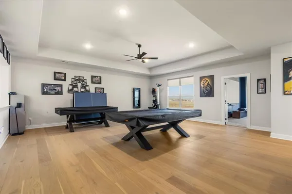 a living room with furniture pool table and a ceiling fan