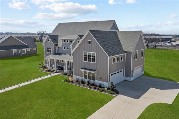 a aerial view of a house with a yard table and chairs
