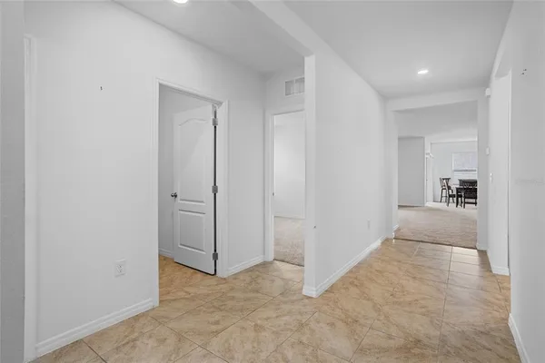 a view of a hallway with a dining table and chairs