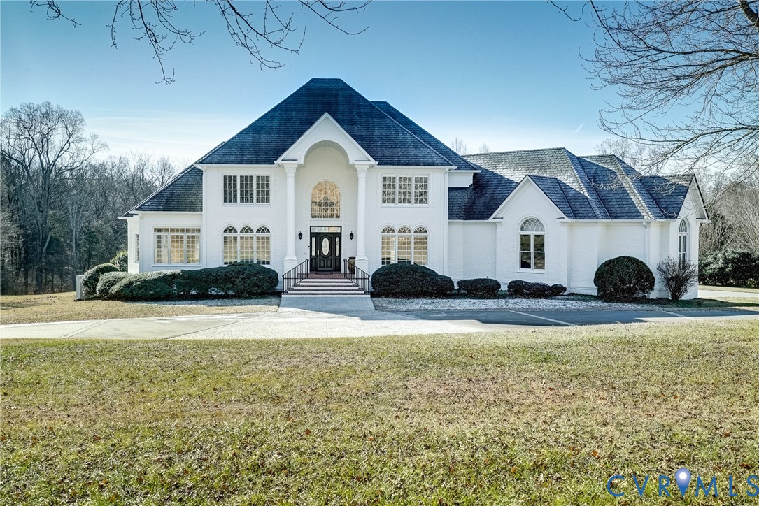 a front view of house with yard and trees in the background