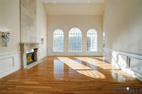 a view of empty room with wooden floor and fireplace