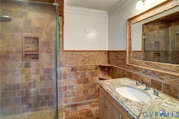 a bathroom with a granite countertop sink a mirror and a shower