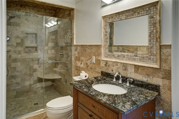 a bathroom with a granite countertop sink a toilet and a mirror