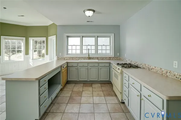 a view of a kitchen with granite countertop a sink and a stove top oven