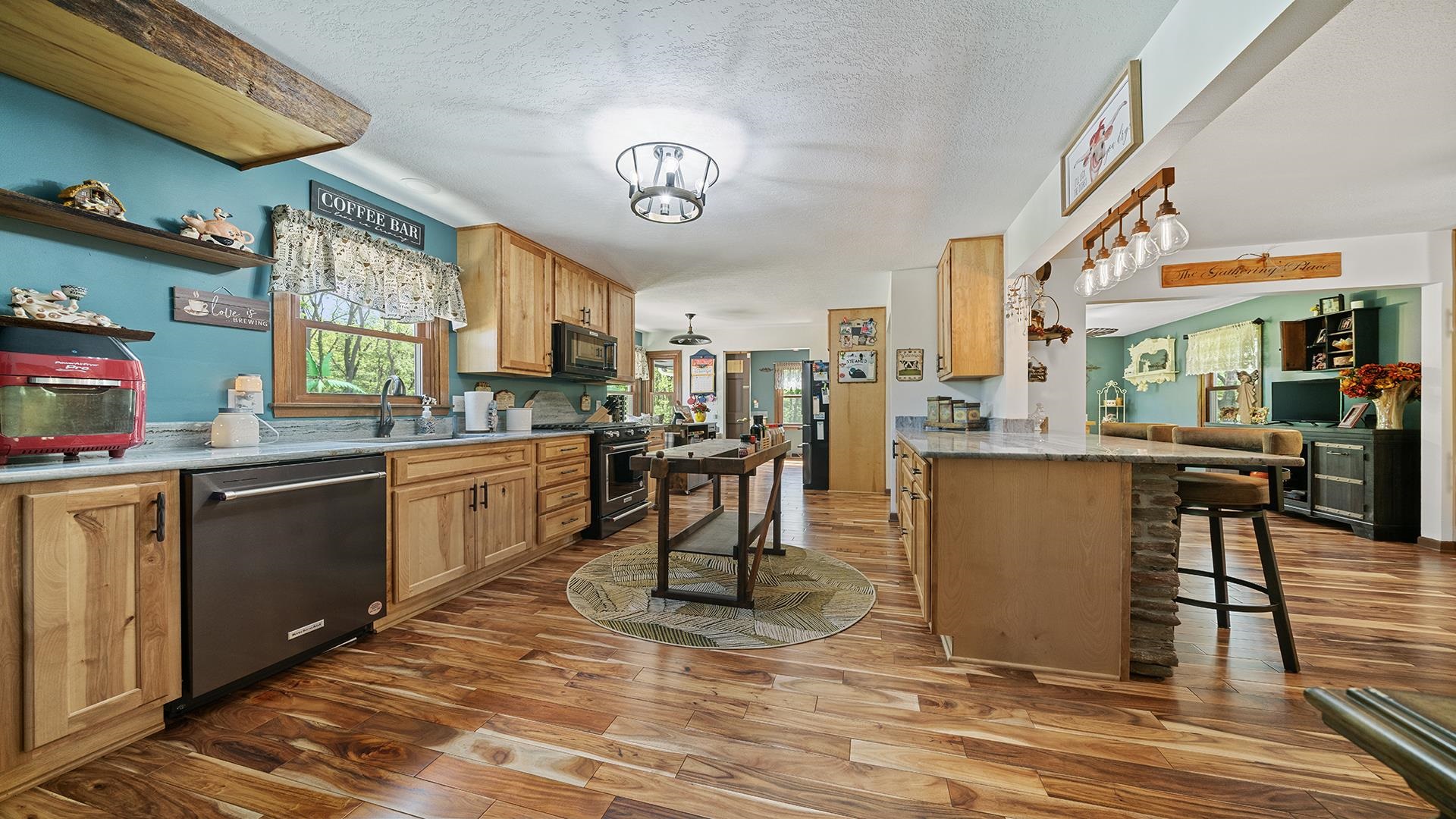 293 Briar Court Oregon, IL 61061 - Photo 21 of 58 a kitchen with stainless steel appliances kitchen island granite countertop a refrigerator a stove top oven and a dining table with wooden floor