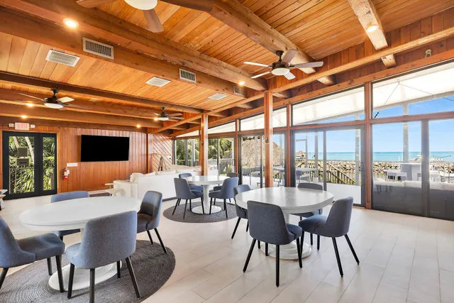 a view of a living room and floor to ceiling windows with wooden floor
