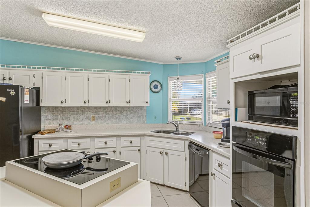 917 Cypress Street Sebastian, FL 32976 - Photo 21 of 80 a kitchen with granite countertop a sink stainless steel appliances and white cabinets