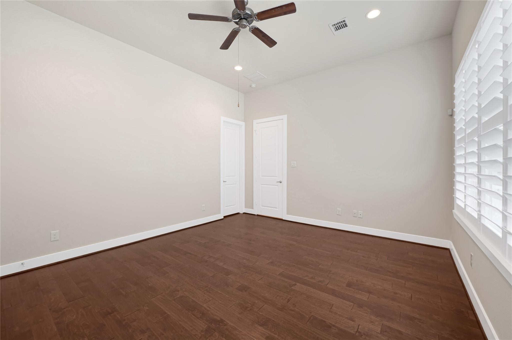 1210 Cedarpost Tree Springs Place, Unit P Houston, TX 77055 - Photo 14 of 25 an empty room with wooden floor fan and windows