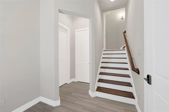 a view of a hallway with wooden floor and entryway